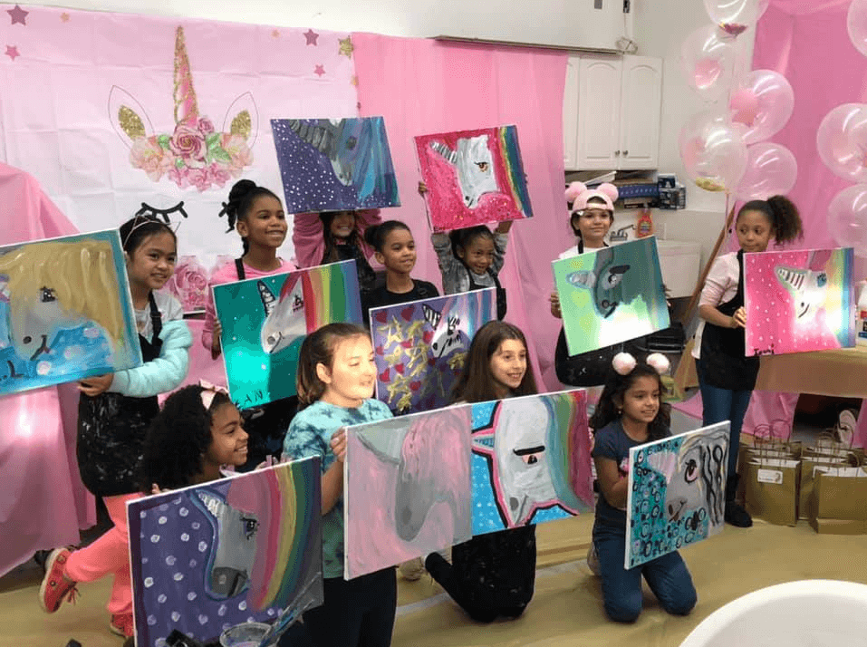 Children raising their paintings at a party
