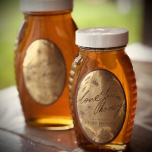 Two jars of golden honey with vintage-style labels.