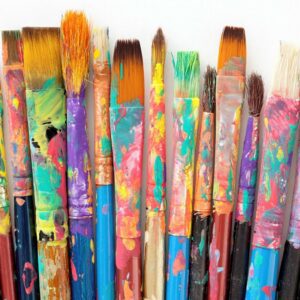 Colorful paintbrushes with vibrant paint on their bristles and handles.